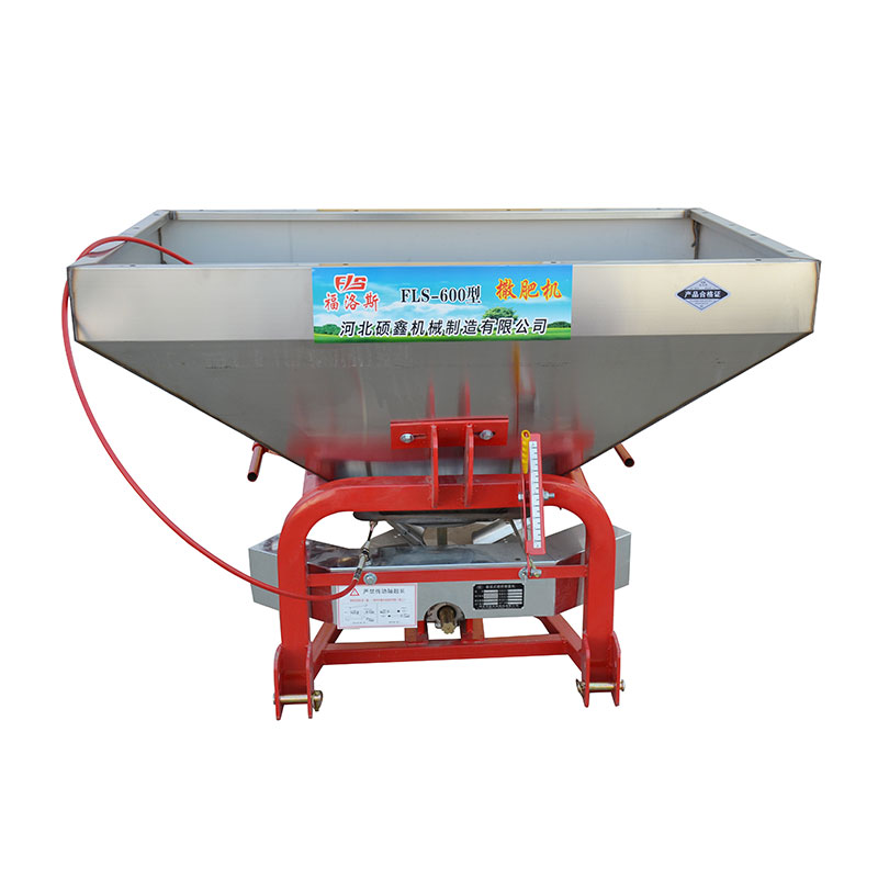 What is the role of a fertilizer spreader?